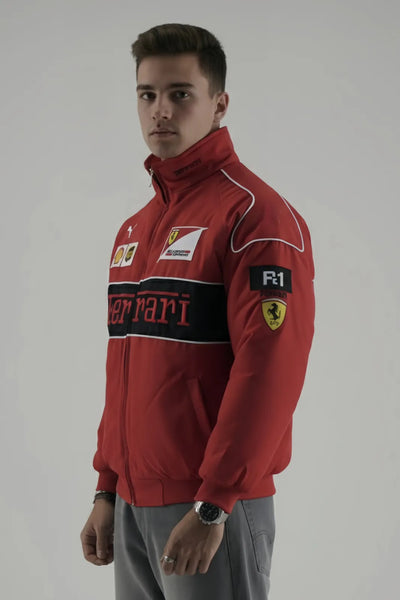 Person wearing a red Ferrari jacket with branding on a plain background giving side pose