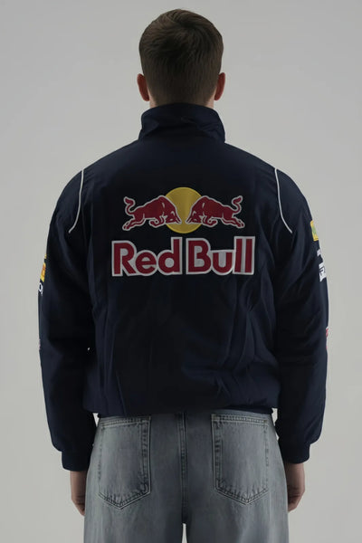 Person wearing a Red Bull F1 Jacket jacket with Red Bull logo on a plain background giving back pose 