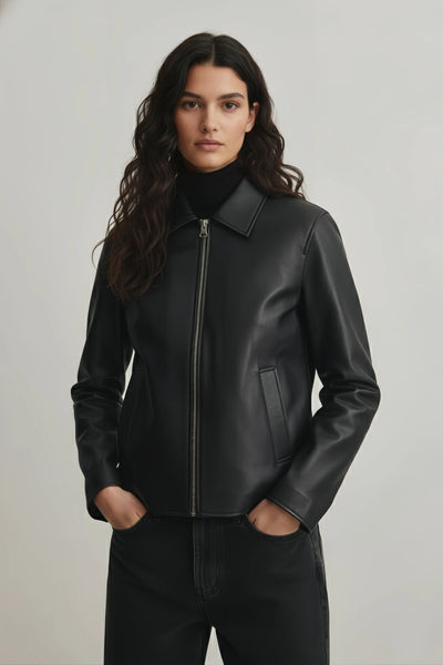 Woman wearing a black leather jacket against a plain background