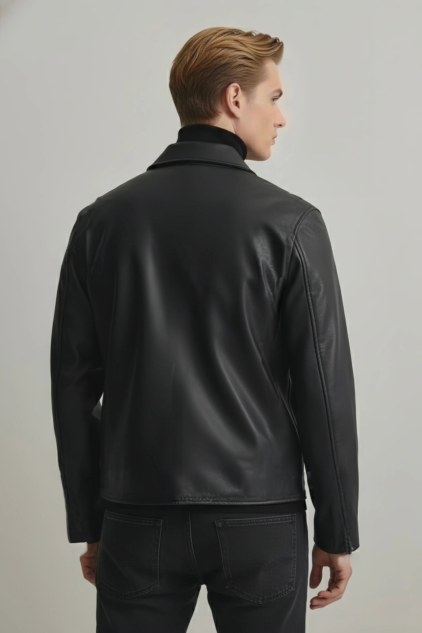 Man wearing a black leather jacket on a plain background