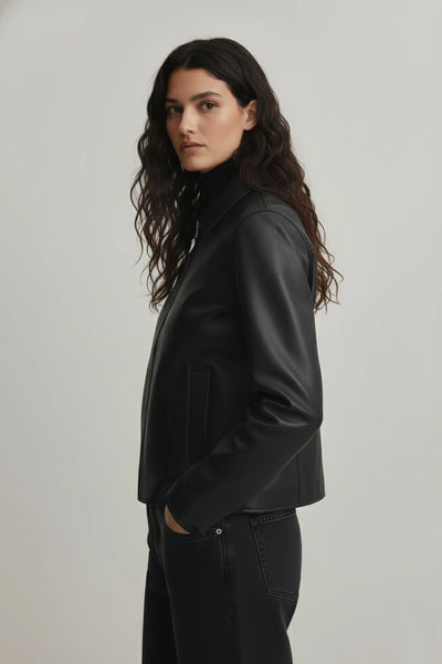 Woman wearing a black leather jacket on a plain background