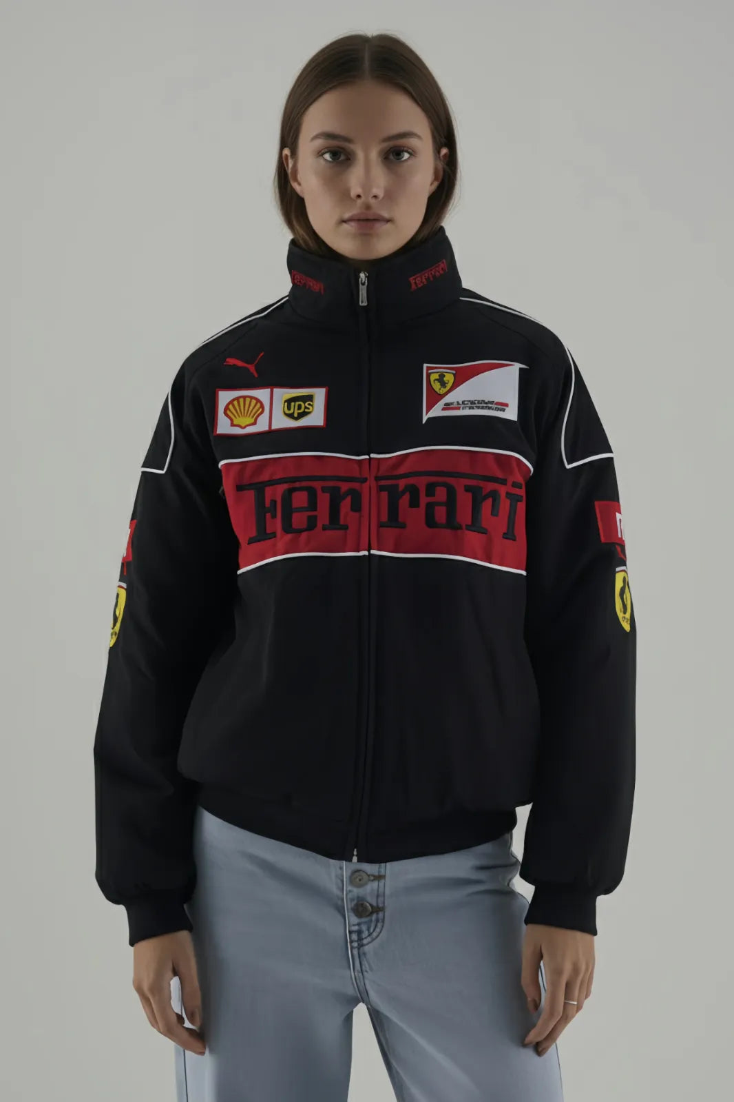 Female Model wearing a black Ferrari jacket with various logos on a gray background