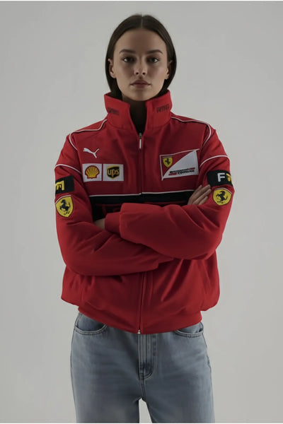 Female Model wearing a red jacket with various logos on a gray background and giving front pose by hand cuffed