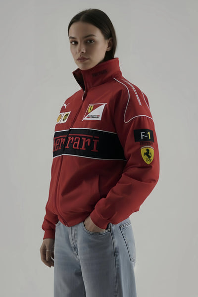 Female Model wearing a red Ferrari sweatshirt with brand logos on a gray background and giving side pose 