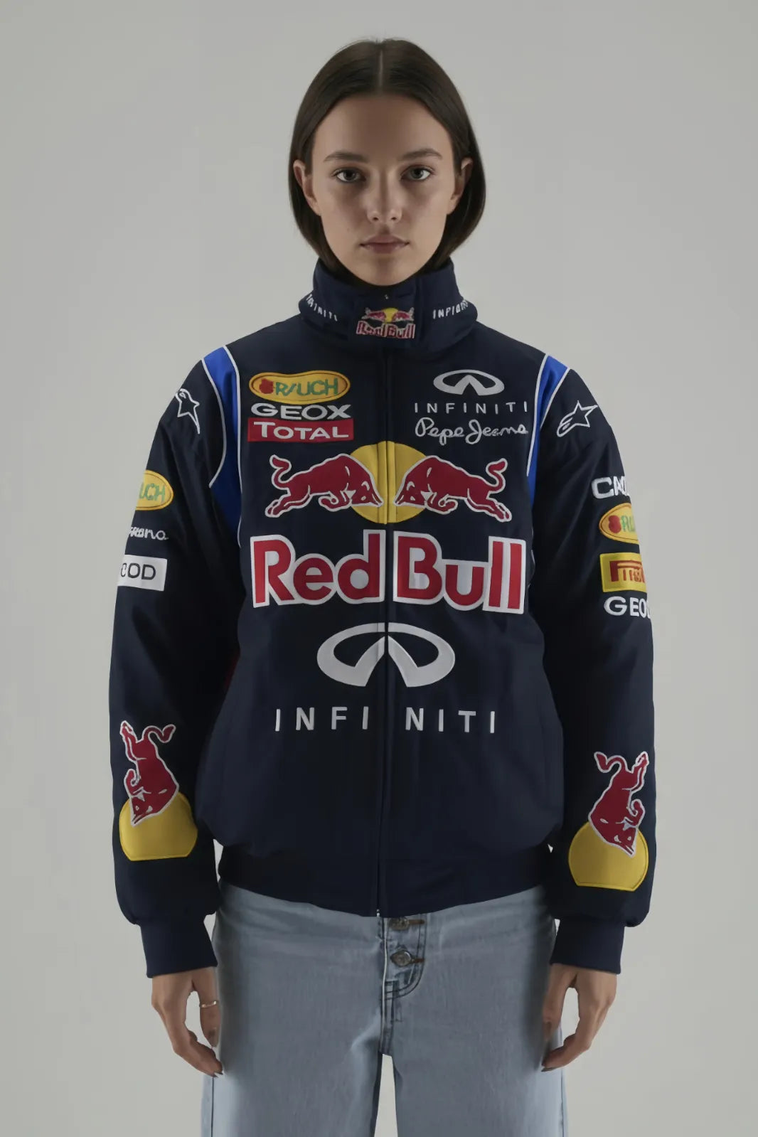 Female Model wearing a Red Bull racing jacket on a plain background giving front pose